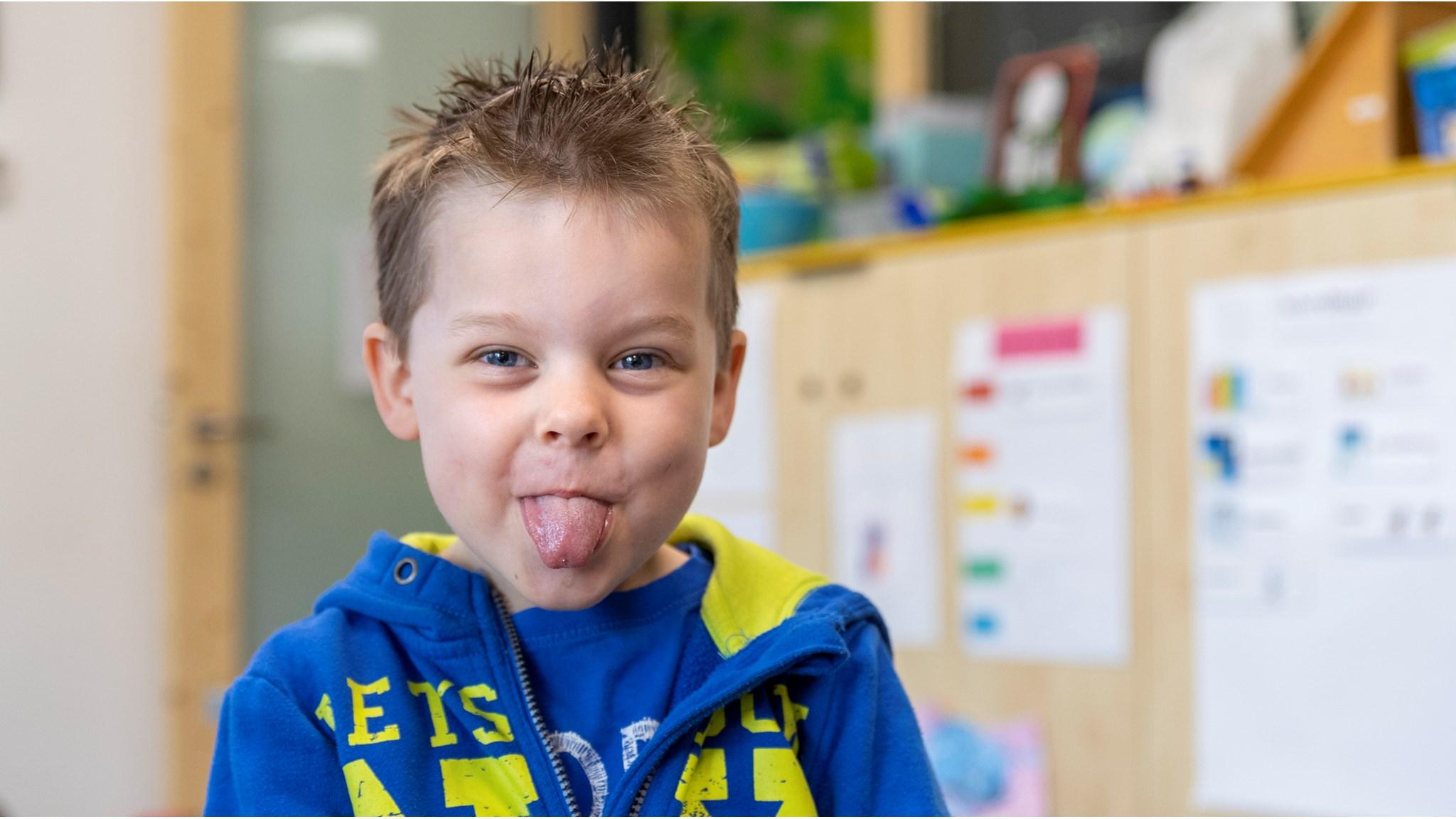 Een jongen met een gestoken tong poseert vrolijk in een klaslokaal op SO Fier in Utrecht. Een jongen met een gestoken tong poseert vrolijk in een klaslokaal op SO Fier in Utrecht.