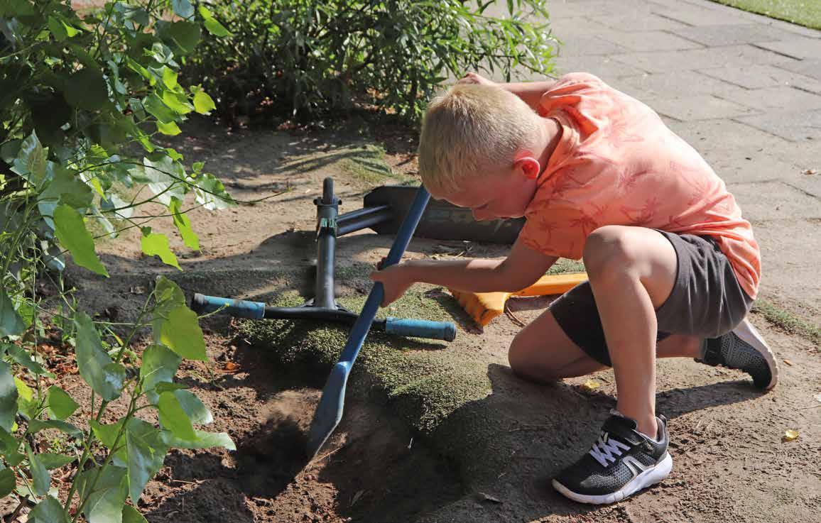 Een jongen op het schoolplein van Protestants Christelijke Basisschool De Schakel in Leersum is aan het graven met een schep. Een jongen op het schoolplein van Protestants Christelijke Basisschool De Schakel in Leersum is aan het graven met een schep.