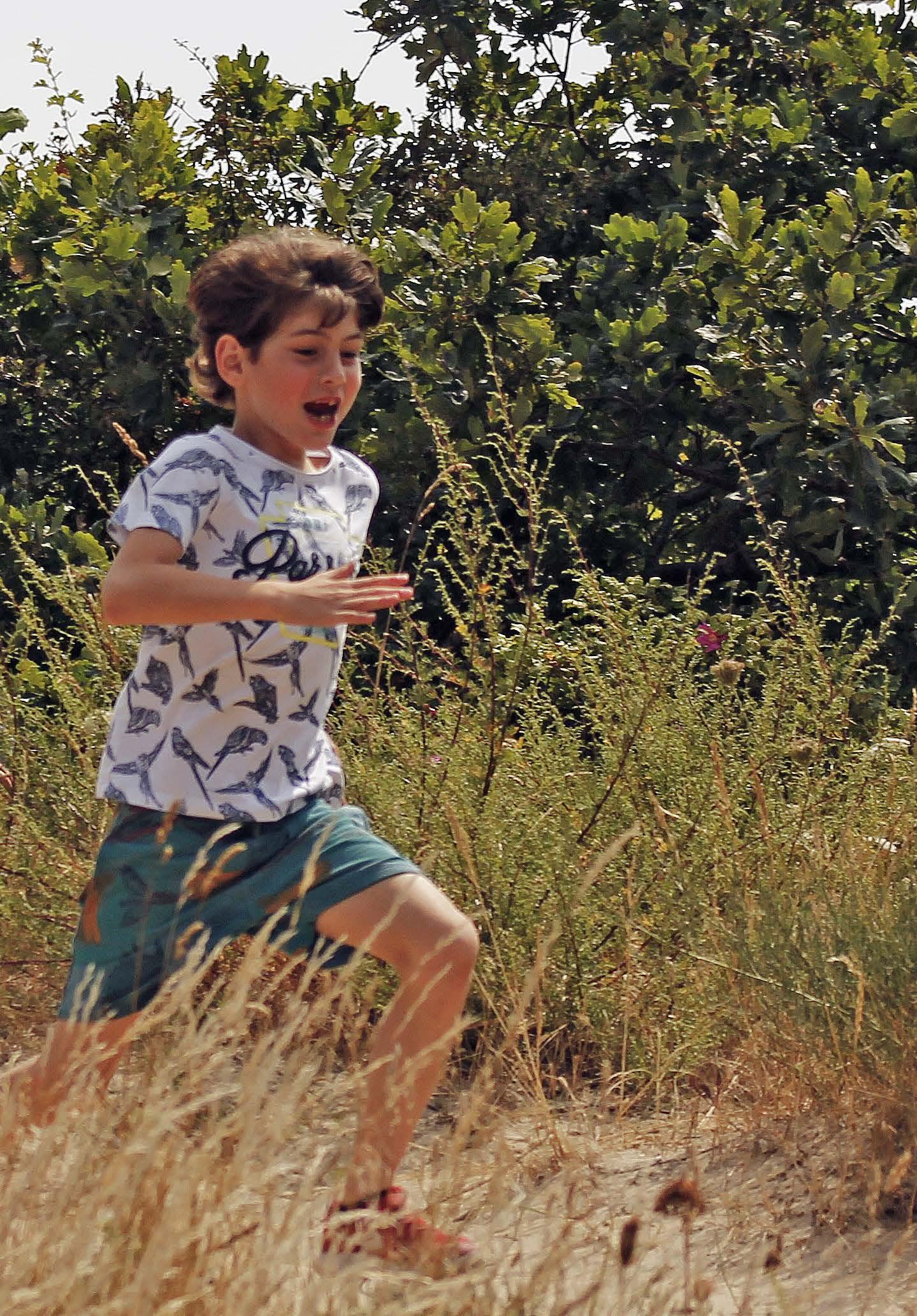 Een jongen rent blij door de natuur bij Openbare basischool De Zeevonk in Zandvoort. Een jongen rent blij door de natuur bij Openbare basischool De Zeevonk in Zandvoort.