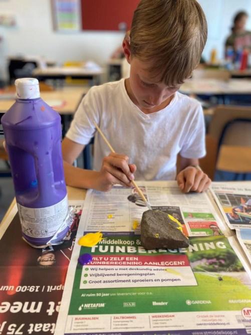 Een jongen schildert een steen tijdens een creatieve activiteit op de Prins Willem Alexanderschool in Ophemert. Een jongen schildert een steen tijdens een creatieve activiteit op de Prins Willem Alexanderschool in Ophemert.