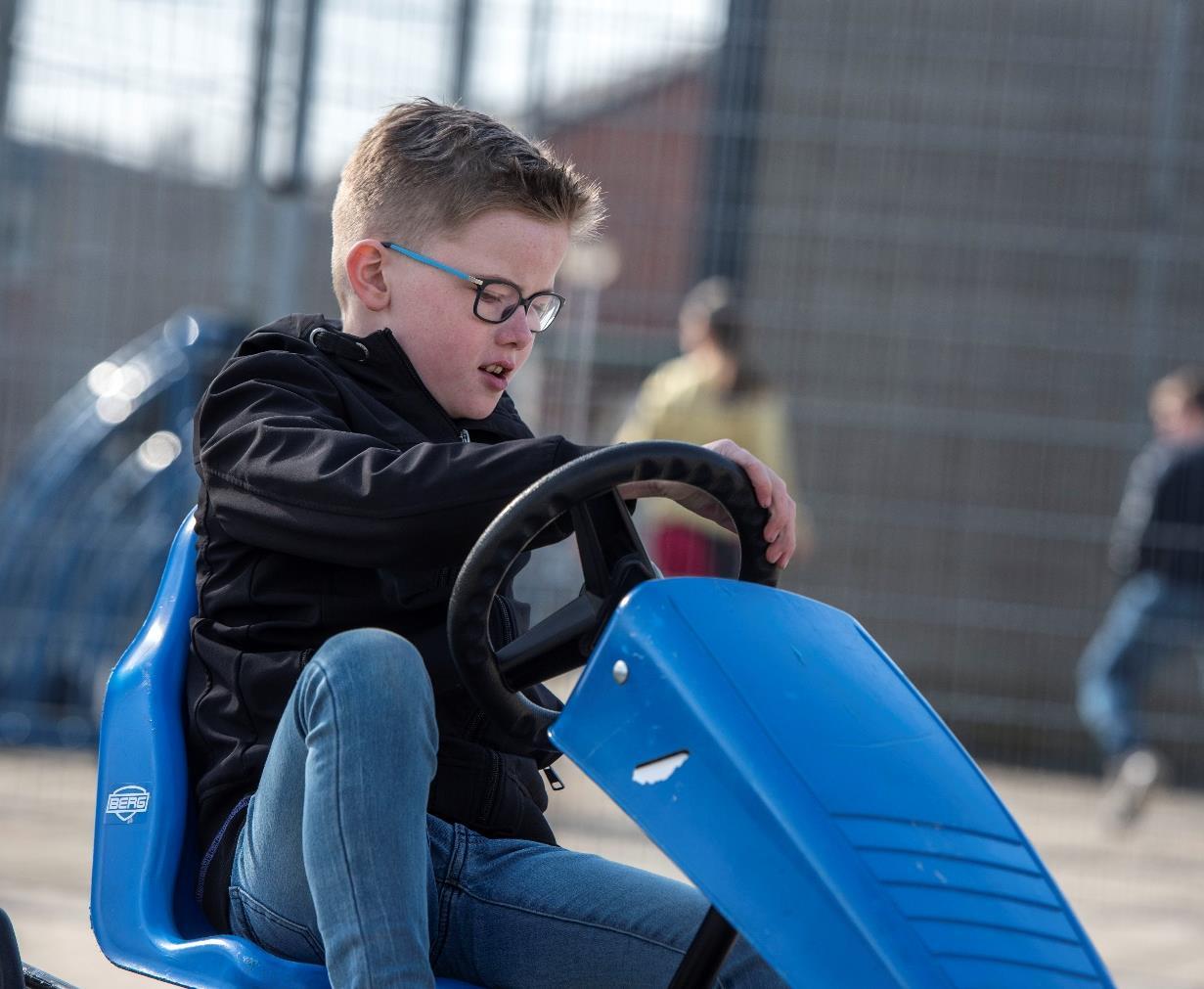 Een jongen speelt met een blauwe skelter op het schoolplein van Het Mozaïek in Almelo. Een jongen speelt met een blauwe skelter op het schoolplein van Het Mozaïek in Almelo.