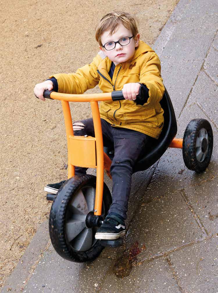 Een jongen speelt op een oranje driewieler op het schoolplein van de Jan Ligthartschool in Arnhem. Een jongen speelt op een oranje driewieler op het schoolplein van de Jan Ligthartschool in Arnhem.