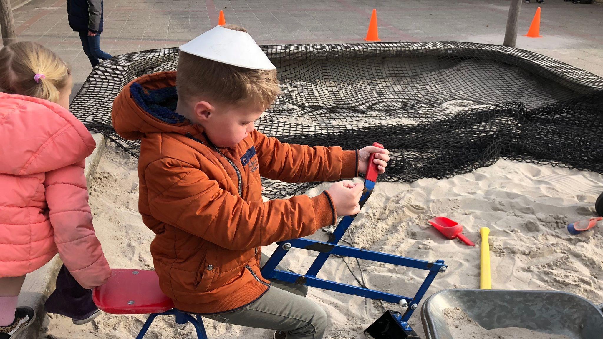 Een jongen speelt op het schoolplein van Basisschool de Wegwijzer in Harderwijk met speelgoed in het zand. Een jongen speelt op het schoolplein van Basisschool de Wegwijzer in Harderwijk met speelgoed in het zand.