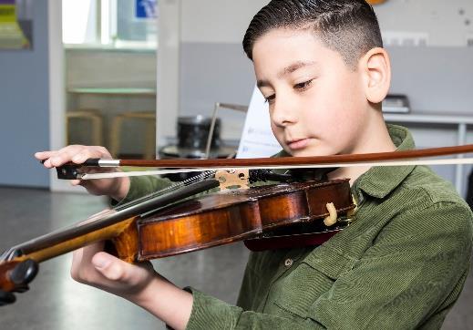 Een jongen speelt viool tijdens muziekles op Basisschool De Botteloef in Amsterdam. Een jongen speelt viool tijdens muziekles op Basisschool De Botteloef in Amsterdam.
