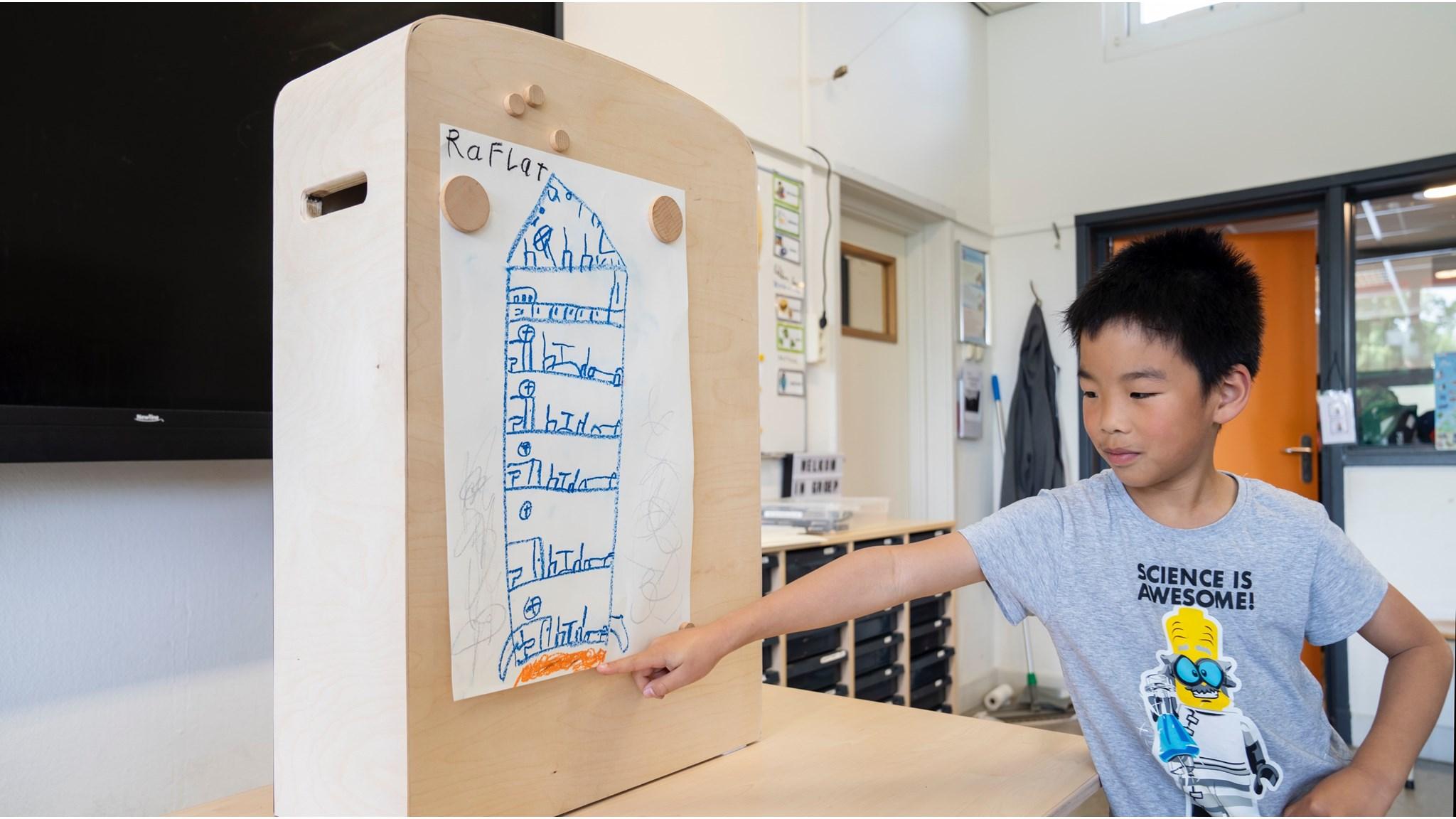 Een jongen toont zijn tekening van een flat in de klas van De Wilakkers in Eindhoven. Een jongen toont zijn tekening van een flat in de klas van De Wilakkers in Eindhoven.