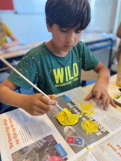 Een jongen van de Prins Willem Alexanderschool in Ophemert is bezig met schilderen in de klas. Een jongen van de Prins Willem Alexanderschool in Ophemert is bezig met schilderen in de klas.
