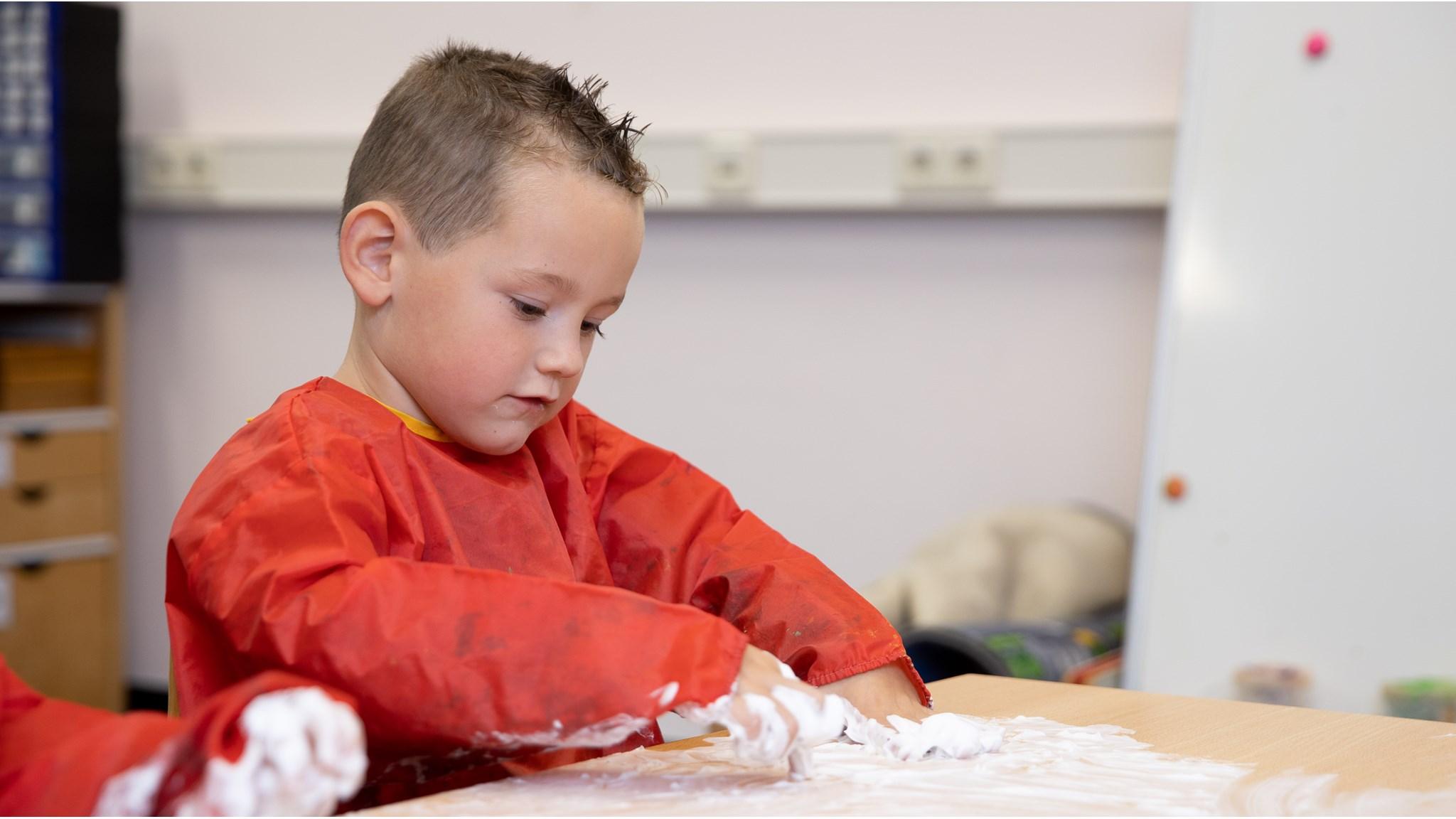 Een jongen werkt geconcentreerd met scheerschuim in de klas van de Ollie B Bommel school in Den Bommel. Een jongen werkt geconcentreerd met scheerschuim in de klas van de Ollie B Bommel school in Den Bommel.