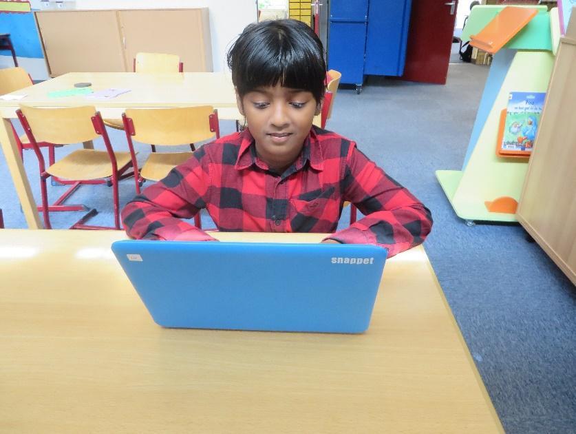 Een jongen werkt geconcentreerd op een laptop in Basisschool de Wegwijzer in Serooskerke (Gem. Veere). Een jongen werkt geconcentreerd op een laptop in Basisschool de Wegwijzer in Serooskerke (Gem. Veere).