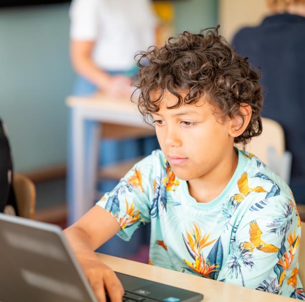 Een jongen werkt geconcentreerd op een laptop in De Kralingsche School voor Basisonderwijs in Rotterdam. Een jongen werkt geconcentreerd op een laptop in De Kralingsche School voor Basisonderwijs in Rotterdam.