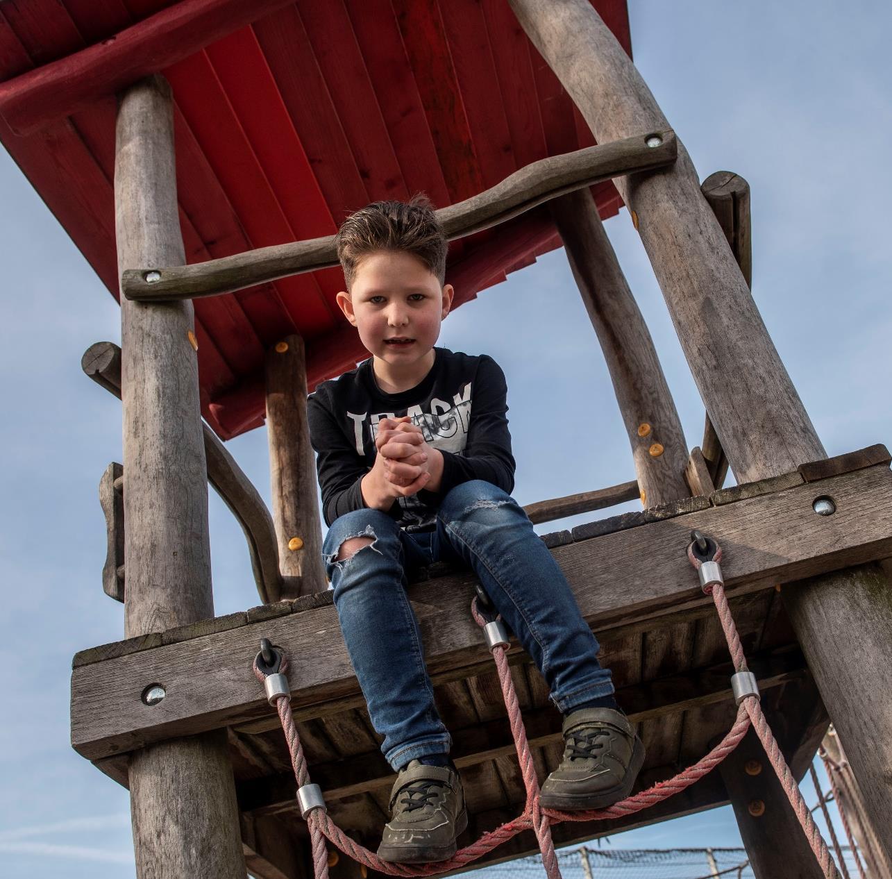 Een jongen zit op een speeltoestel op het schoolplein van Het Mozaïek in Almelo. Een jongen zit op een speeltoestel op het schoolplein van Het Mozaïek in Almelo.