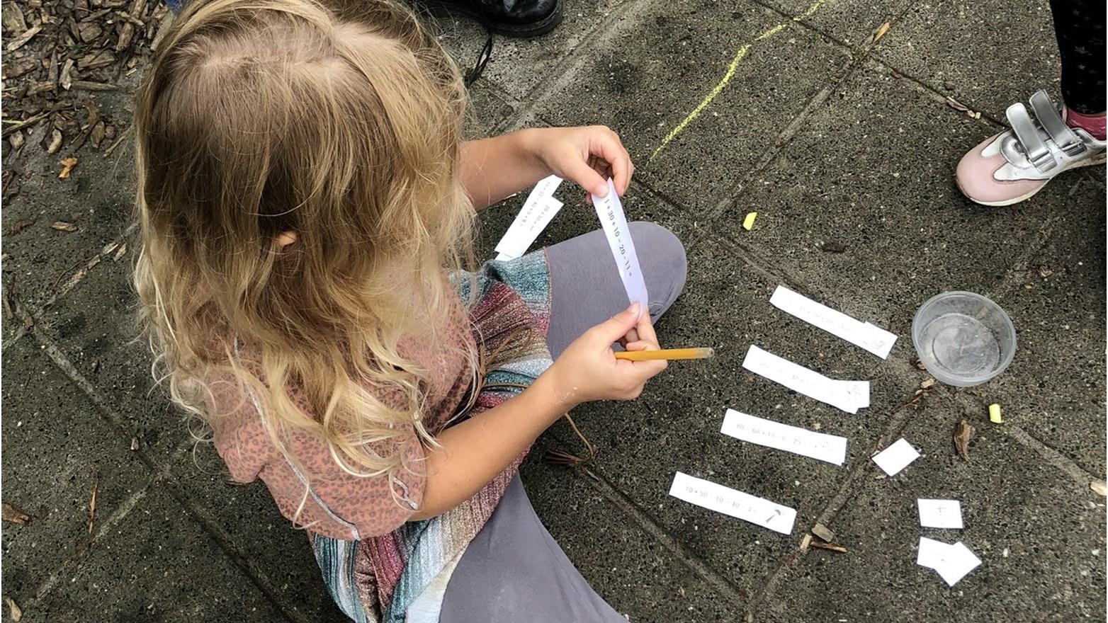 Een kind bezig met knutselen op het schoolplein van Openbare Basisschool Kromme Akkers in Garnwerd. Een kind bezig met knutselen op het schoolplein van Openbare Basisschool Kromme Akkers in Garnwerd.