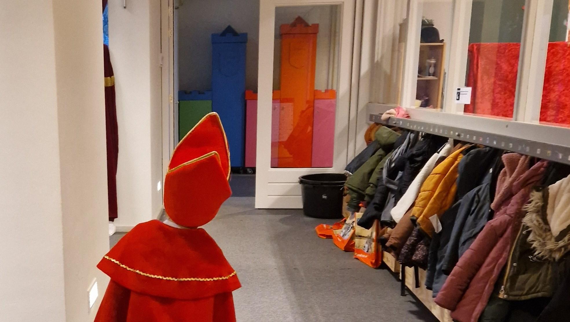 Een kind in een Sinterklaas-costuum staat in de gang van de Mariaschool in Vinkel (Gem. 's-Hertogenbosch). Een kind in een Sinterklaas-costuum staat in de gang van de Mariaschool in Vinkel (Gem. 's-Hertogenbosch).