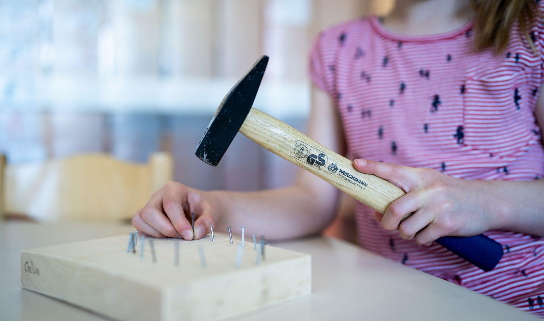 Een kind leert timmeren met een hamer op de Hubertusschool in Herten. Een kind leert timmeren met een hamer op de Hubertusschool in Herten.