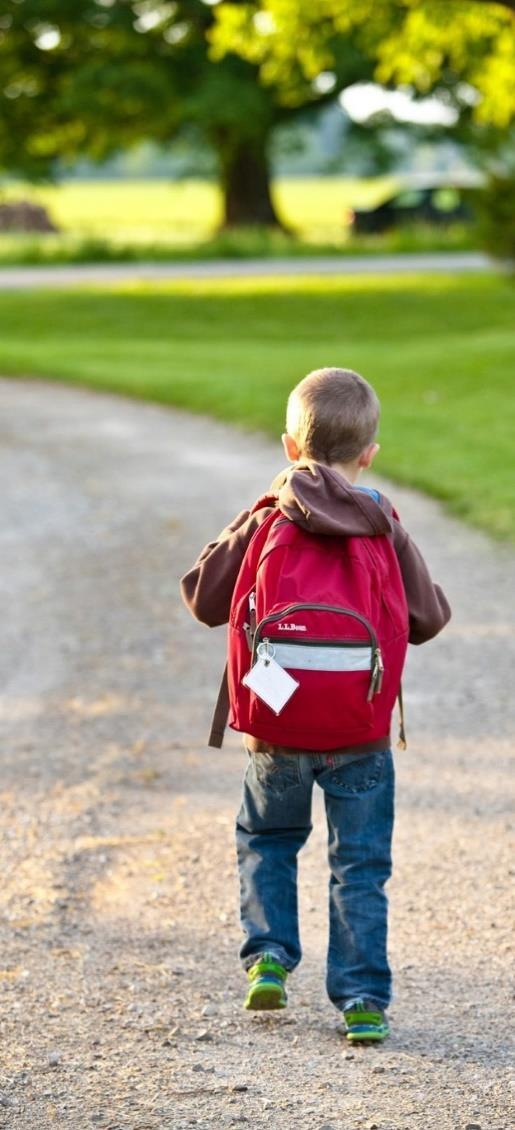 Een kind loopt met een rode rugzak naar OEC.Basisschool De Kubus in Zwolle. Een kind loopt met een rode rugzak naar OEC.Basisschool De Kubus in Zwolle.