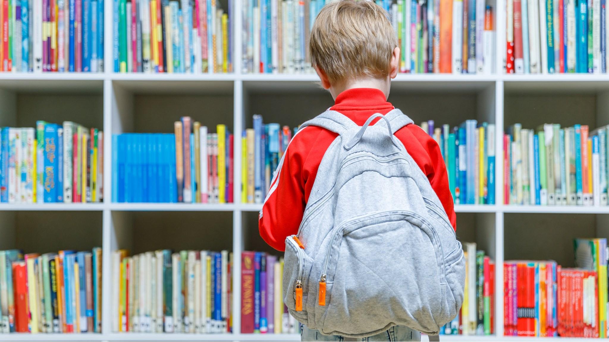 Een kind met een grijze rugzak kijkt naar de boekenkast in Odbs Puntenburg in Utrecht. Een kind met een grijze rugzak kijkt naar de boekenkast in Odbs Puntenburg in Utrecht.