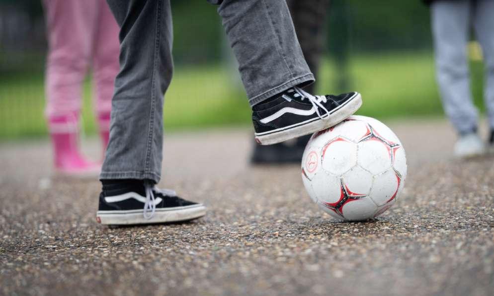Een kind schopt tegen een voetbal op het schoolplein van Openbare Basisschool De Flierefluiter in Almere. Een kind schopt tegen een voetbal op het schoolplein van Openbare Basisschool De Flierefluiter in Almere.