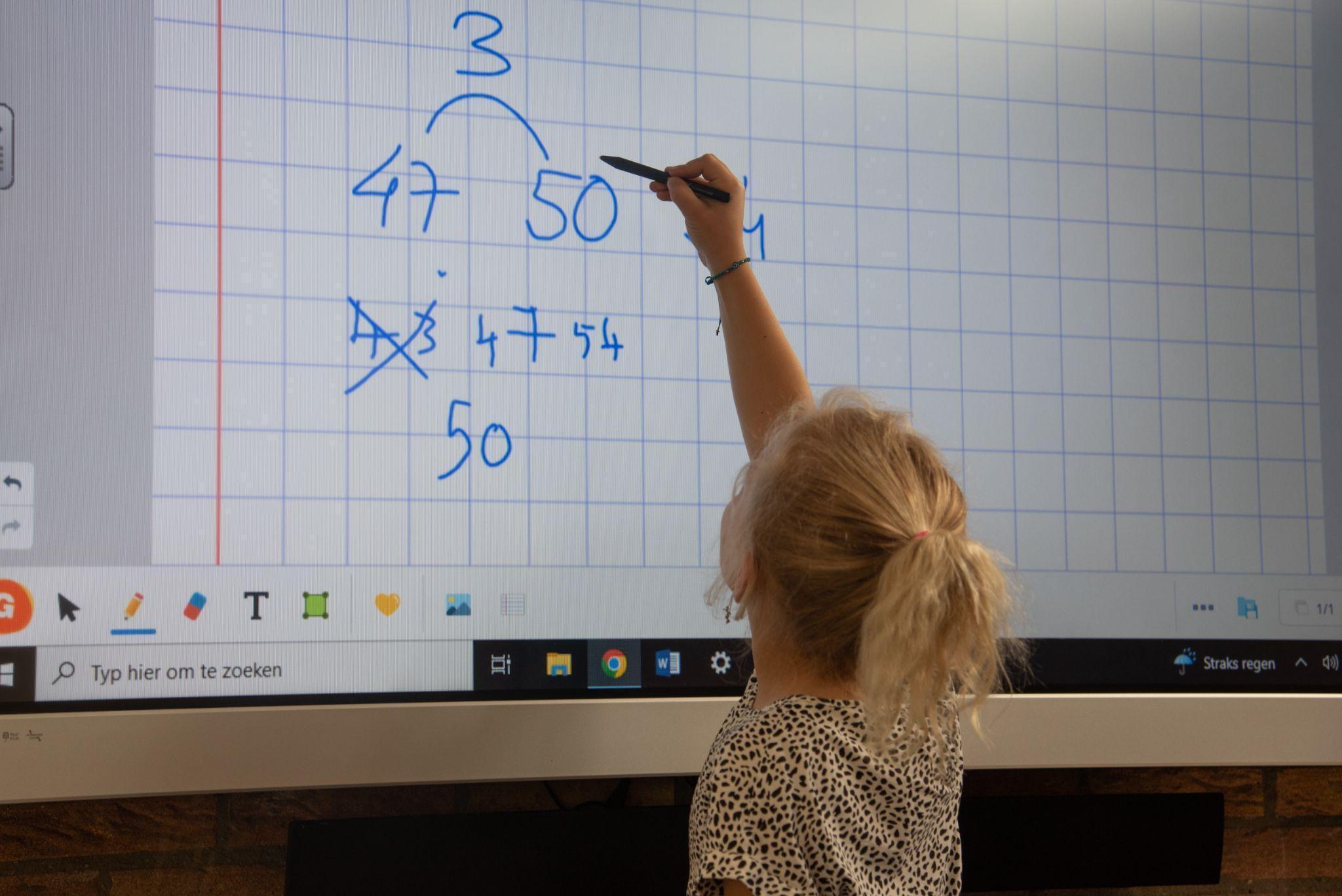 Een kind schrijft op een digitaal bord in de klas van Basisschool Wisperweide in Weesp. Een kind schrijft op een digitaal bord in de klas van Basisschool Wisperweide in Weesp.