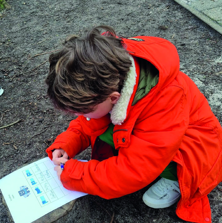 Een kind schrijft op het schoolplein van Kindcentrum Het Baken in Sint Pancras.