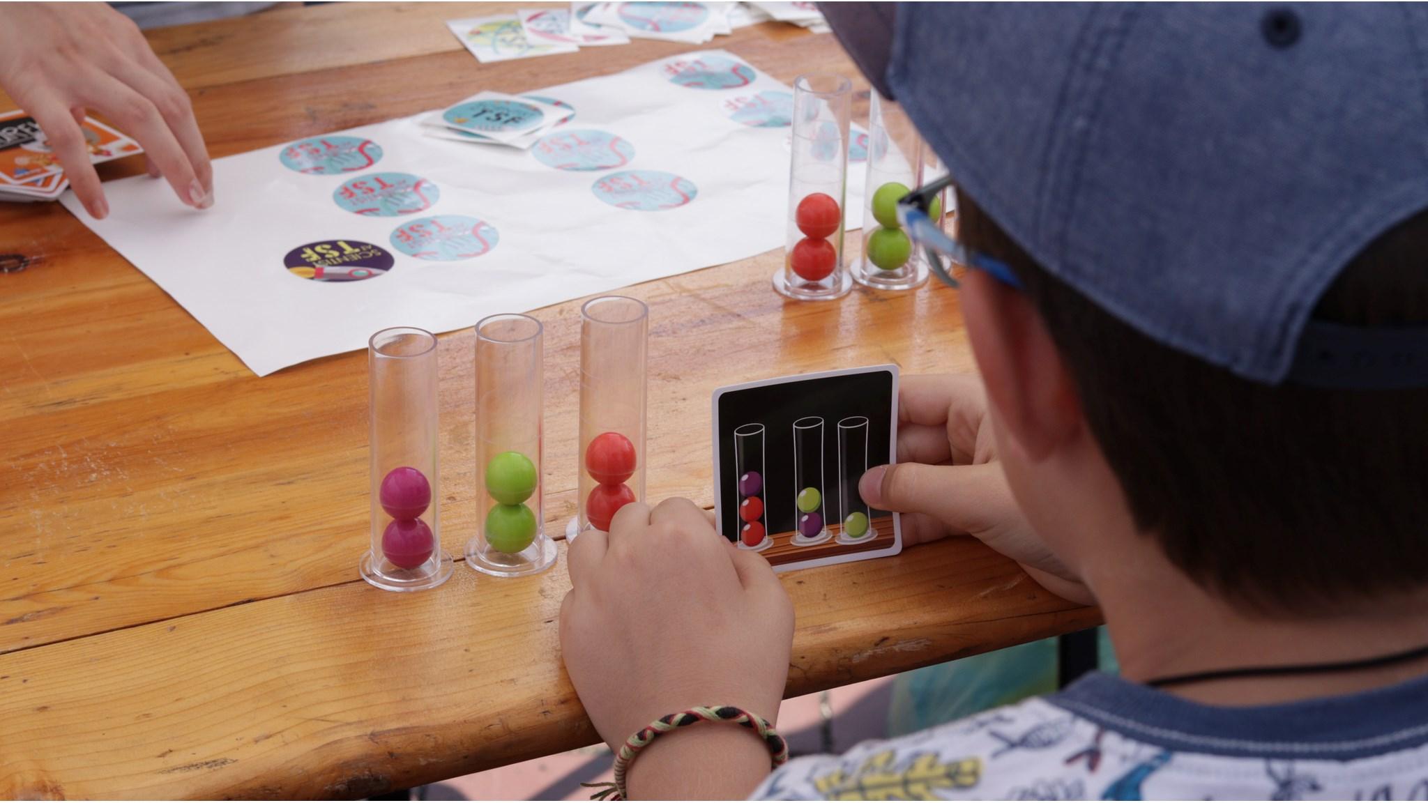 Een kind speelt een educatief spel met kleurrijke ballen op het schoolplein van obs De Campherbeek in Zwolle.