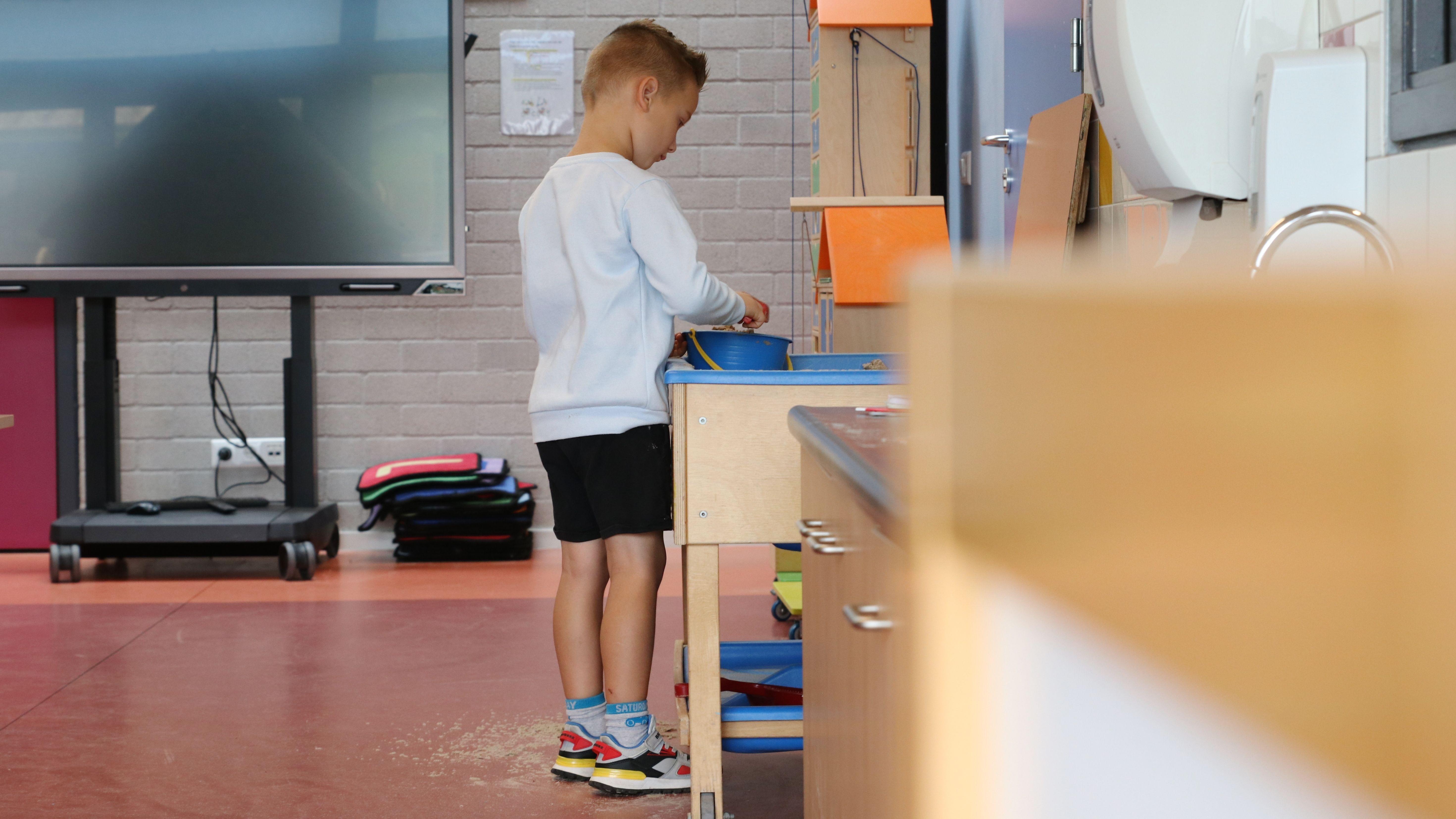 Een kind speelt met een blauwe emmer in de klas van IBS De Schittering in Hooge Zwaluwe. Een kind speelt met een blauwe emmer in de klas van IBS De Schittering in Hooge Zwaluwe.