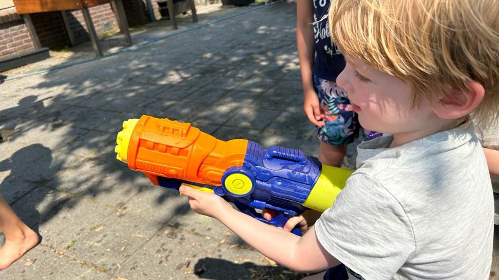 Een kind speelt met een waterpistool op het schoolplein van Openbare Basisschool Kromme Akkers in Garnwerd. Een kind speelt met een waterpistool op het schoolplein van Openbare Basisschool Kromme Akkers in Garnwerd.