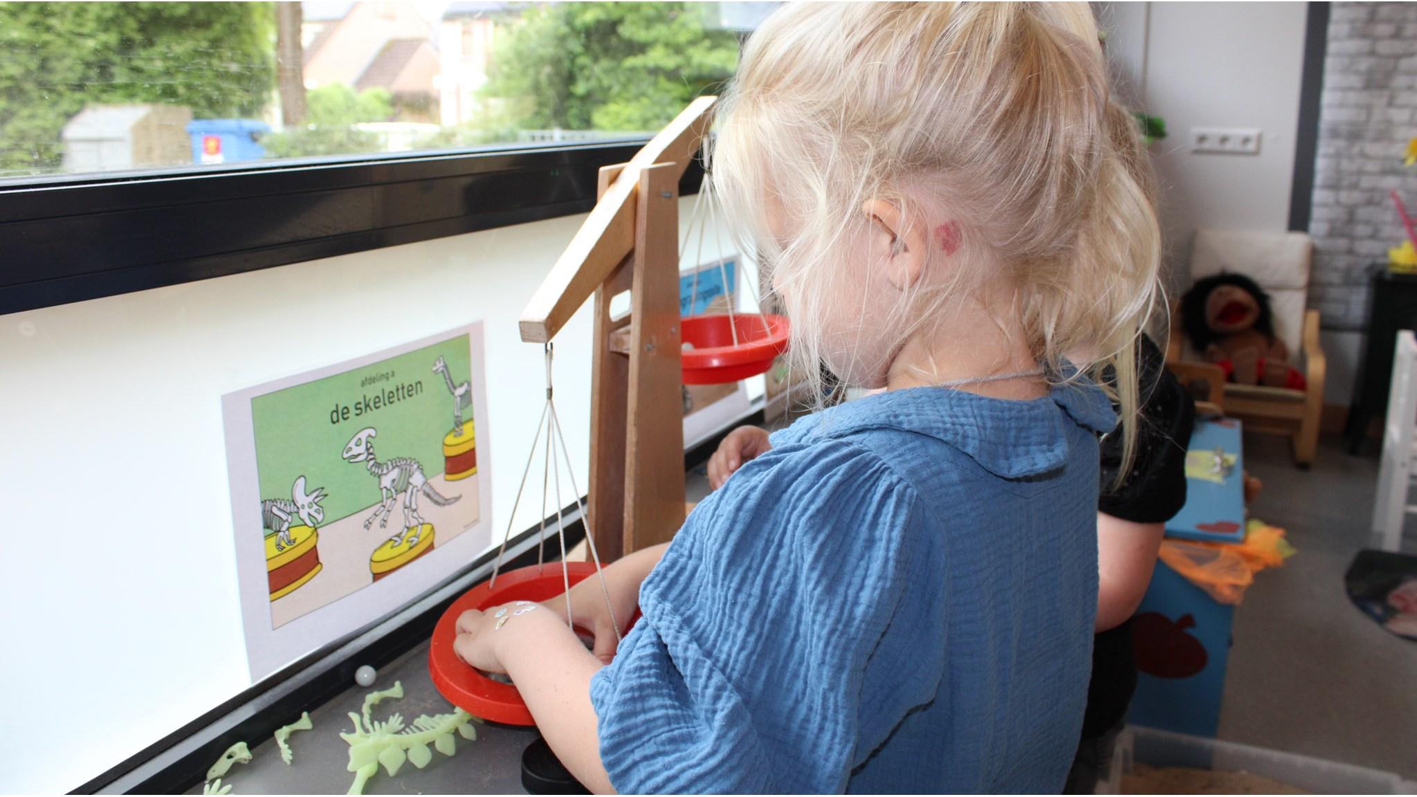 Een kind speelt met een weegschaal in de klas van Openbare Basisschool de Kraaienboom in Benningbroek. Een kind speelt met een weegschaal in de klas van Openbare Basisschool de Kraaienboom in Benningbroek.