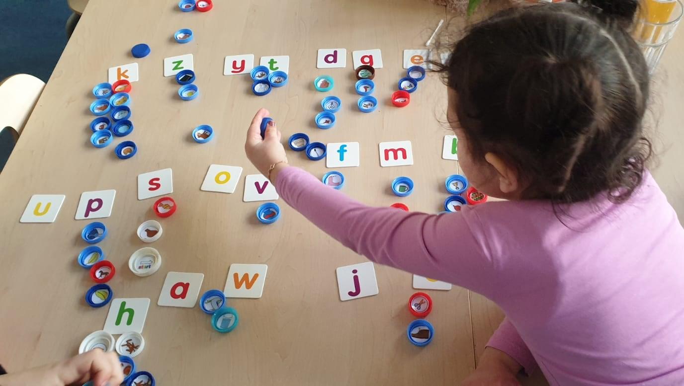 Een kind speelt met kleurrijke speelstukken en letters in een activiteit voor leerlingen van De Zijderoute in Amsterdam. Een kind speelt met kleurrijke speelstukken en letters in een activiteit voor leerlingen van De Zijderoute in Amsterdam.