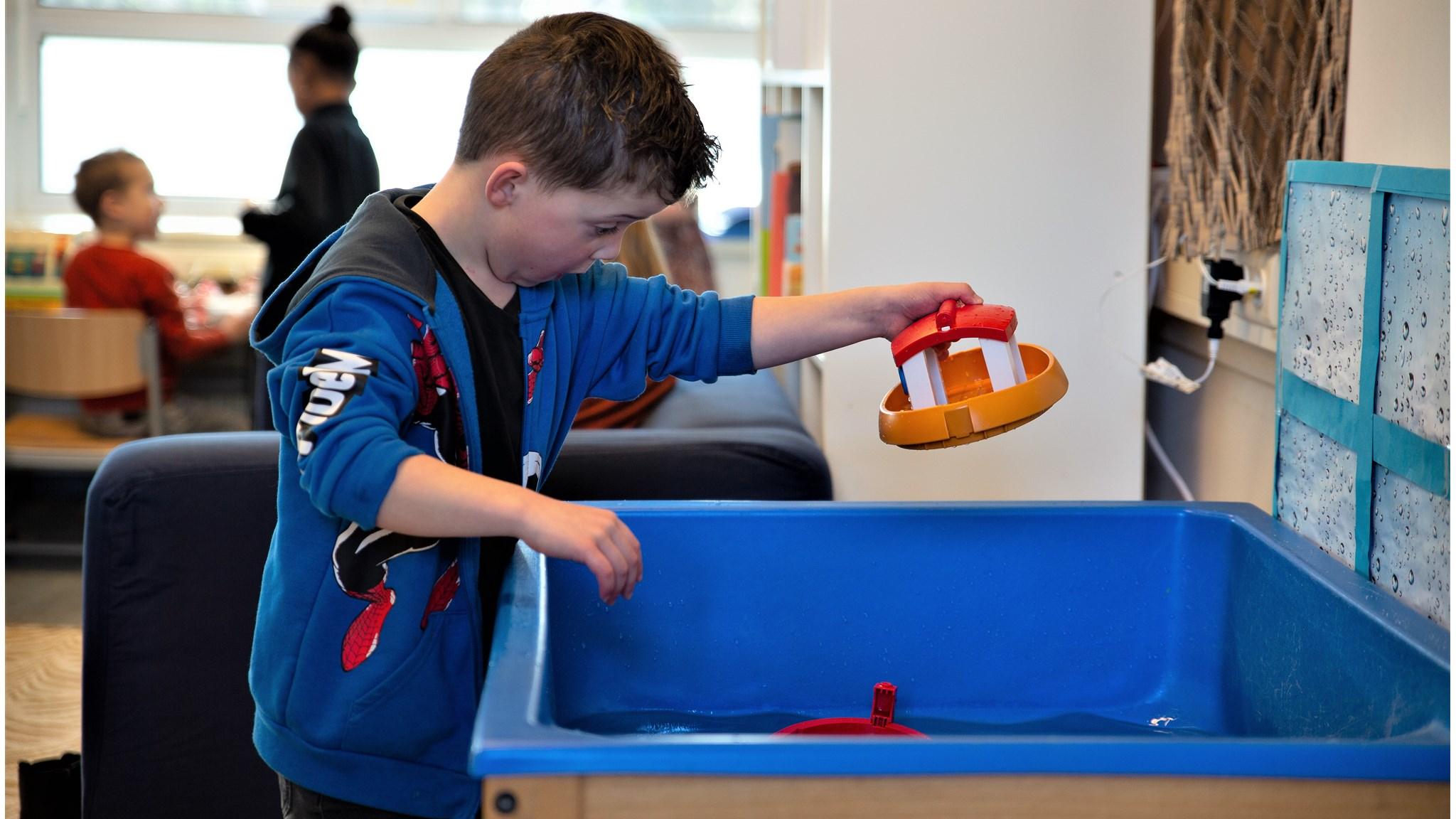 Een kind speelt met speelgoed in een waterbak bij SBO De Toekomst in Dordrecht. Een kind speelt met speelgoed in een waterbak bij SBO De Toekomst in Dordrecht.