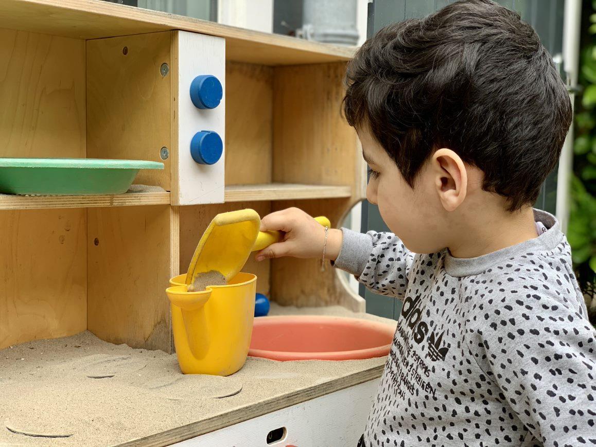 Een kind speelt met zand in de speelruimte van de Prinses Marijkeschool in Den Haag. Een kind speelt met zand in de speelruimte van de Prinses Marijkeschool in Den Haag.