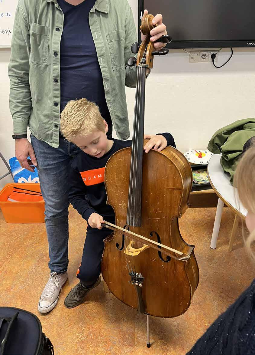 Een kind speelt op een cello onder begeleiding van een volwassene op De Meander in Nieuwegein.