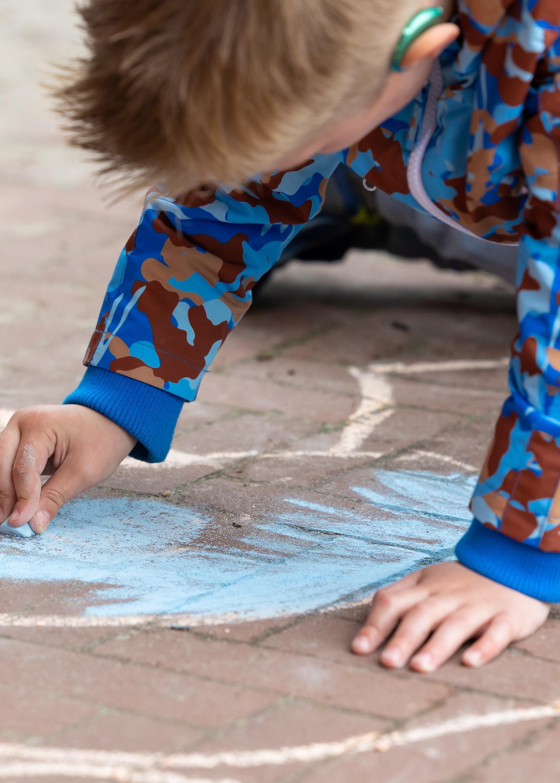 Een kind tekent met krijt op het schoolplein van Openbaar Kindcentrum de Springplank in Heino. Een kind tekent met krijt op het schoolplein van Openbaar Kindcentrum de Springplank in Heino.