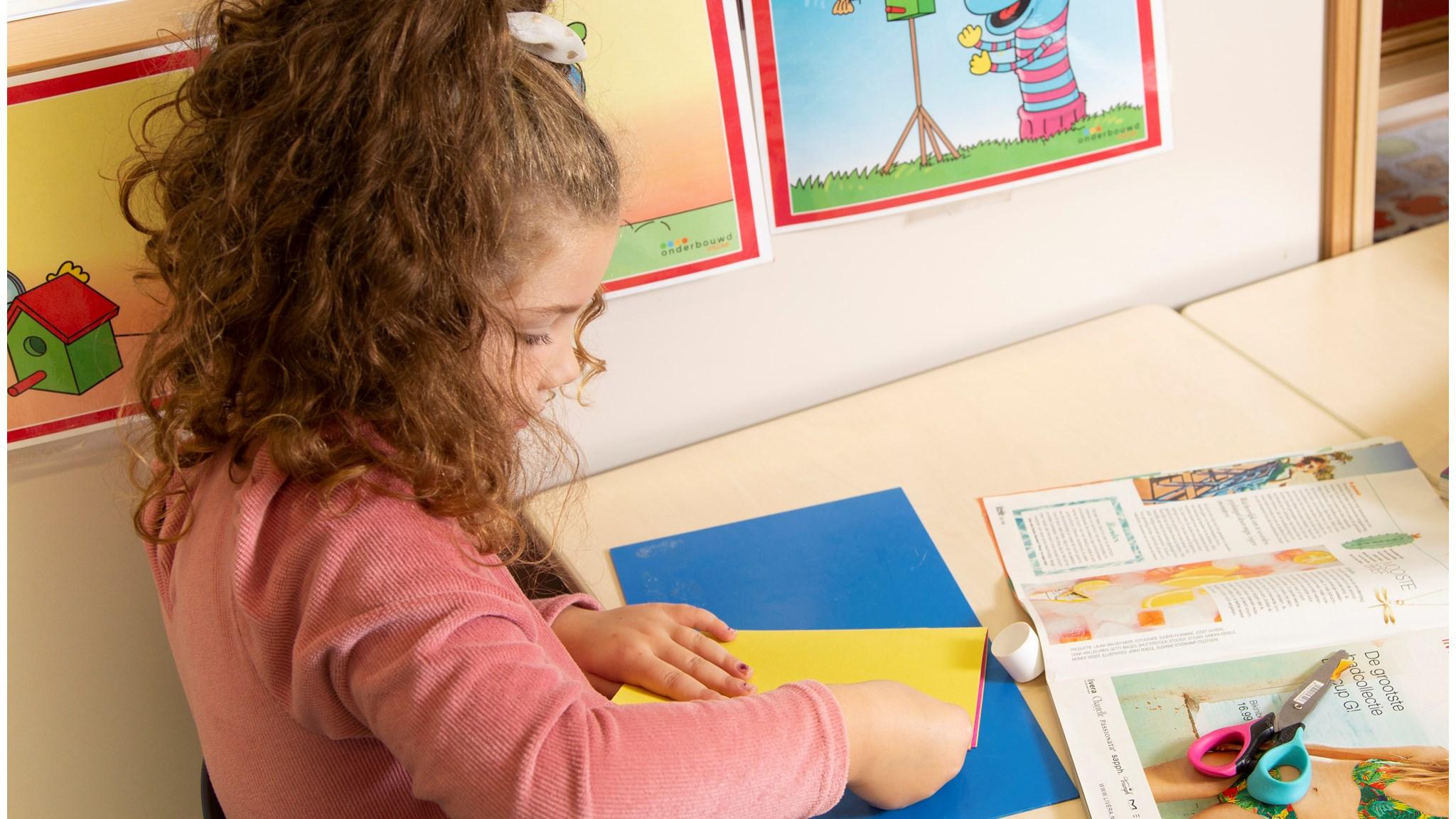 Een kind van CBS de Parel in Muntendam is bezig met knutselen aan een tafel. Een kind van CBS de Parel in Muntendam is bezig met knutselen aan een tafel.