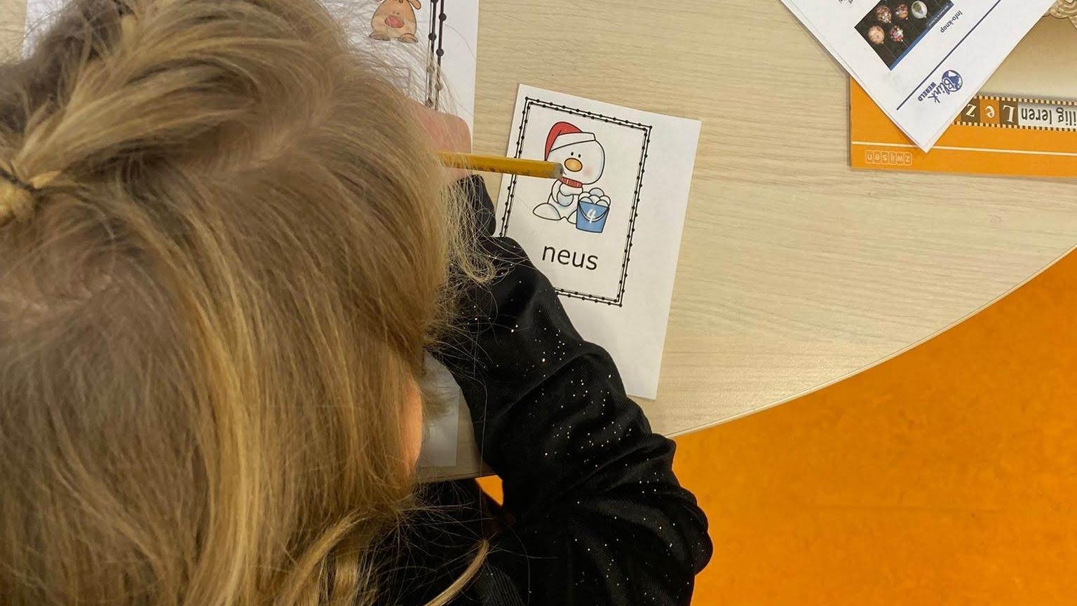 Een kind van CBS de Verbinding in Musselkanaal is bezig met een tekening van een sneeuwpop met het woord "neus". Een kind van CBS de Verbinding in Musselkanaal is bezig met een tekening van een sneeuwpop met het woord "neus".