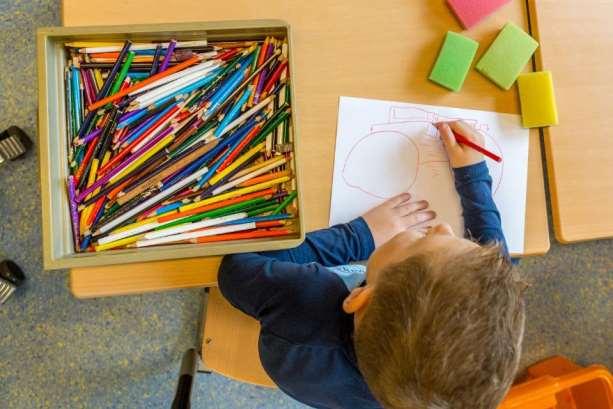Een kind van de Antoniusschool in Kudelstaart kleurt met kleurpotloden en tekent op een vel papier. Een kind van de Antoniusschool in Kudelstaart kleurt met kleurpotloden en tekent op een vel papier.