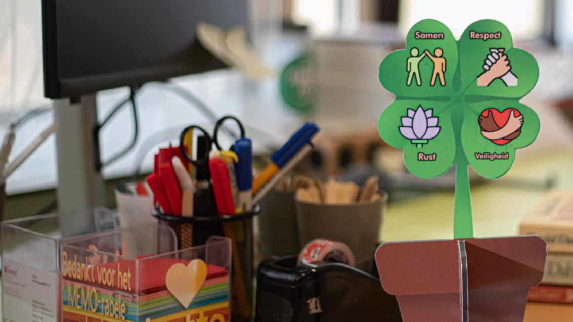 Een kleurrijke decoratie met symbolen voor samen, respect, rust en veiligheid op het bureau van Basisschool 't Kwekkeveld in Schijndel.