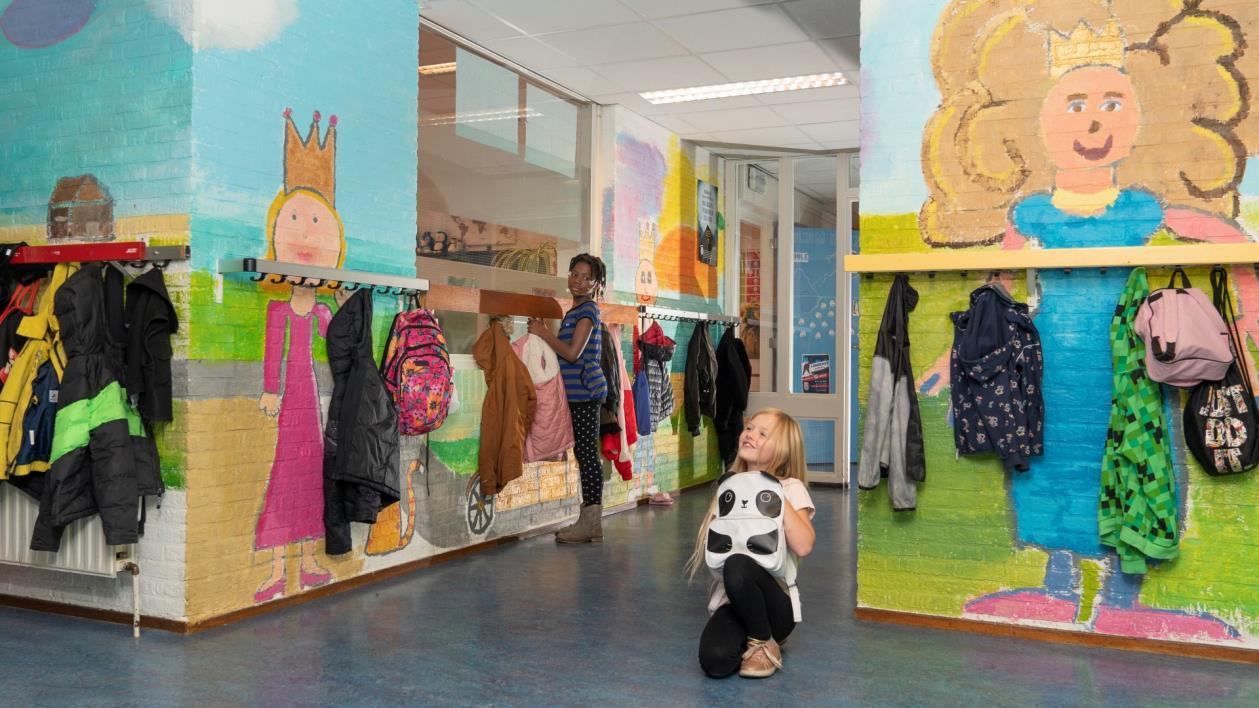 Een kleurrijke gang van IKC De Heerdstee in Groningen, waar kinderen hun jassen ophangen en spelen. Een kleurrijke gang van IKC De Heerdstee in Groningen, waar kinderen hun jassen ophangen en spelen.