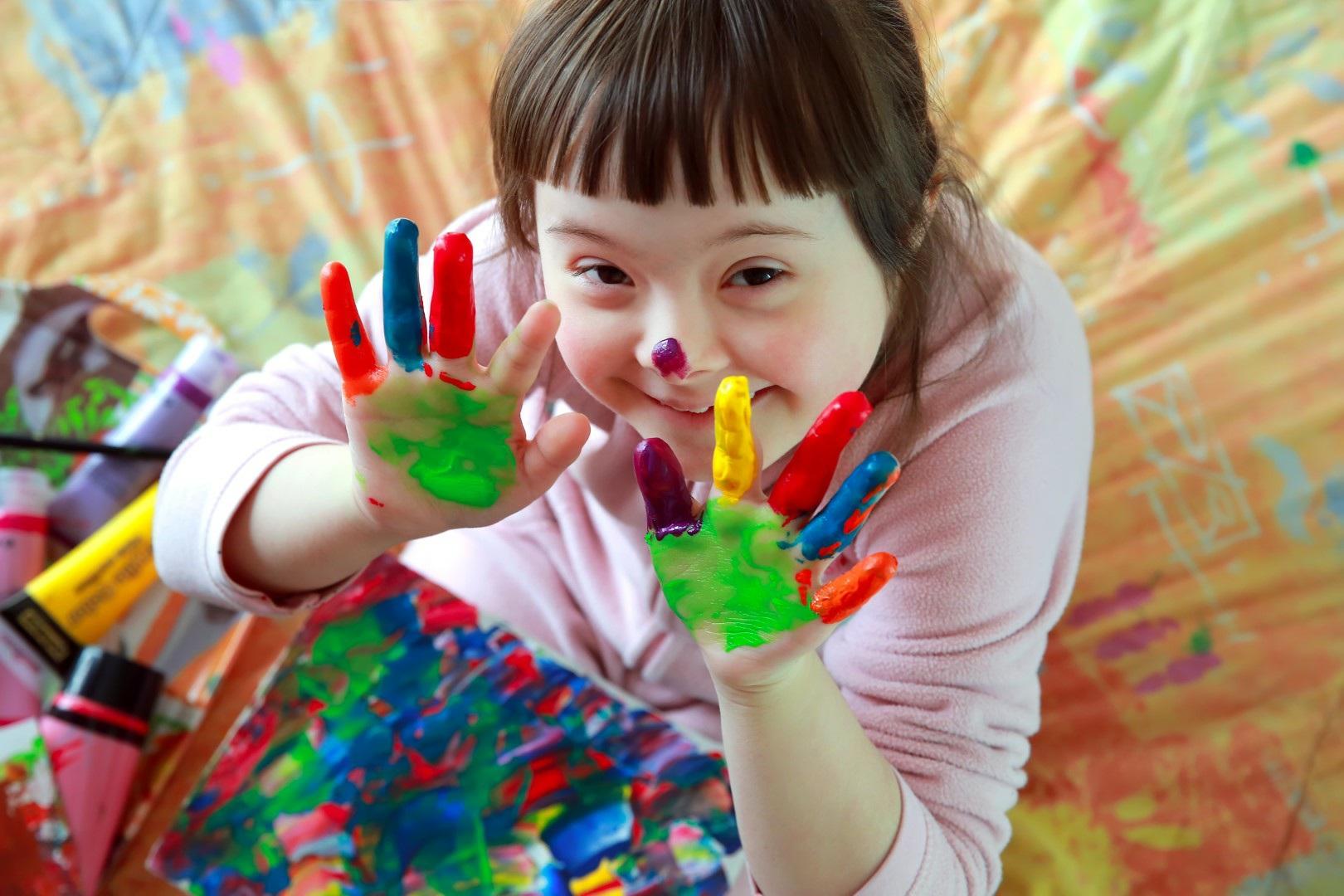 Een lachend meisje met beschilderde handen speelt creatieve activiteiten op ZML de Ark Oud-Beijerland. Een lachend meisje met beschilderde handen speelt creatieve activiteiten op ZML de Ark Oud-Beijerland.