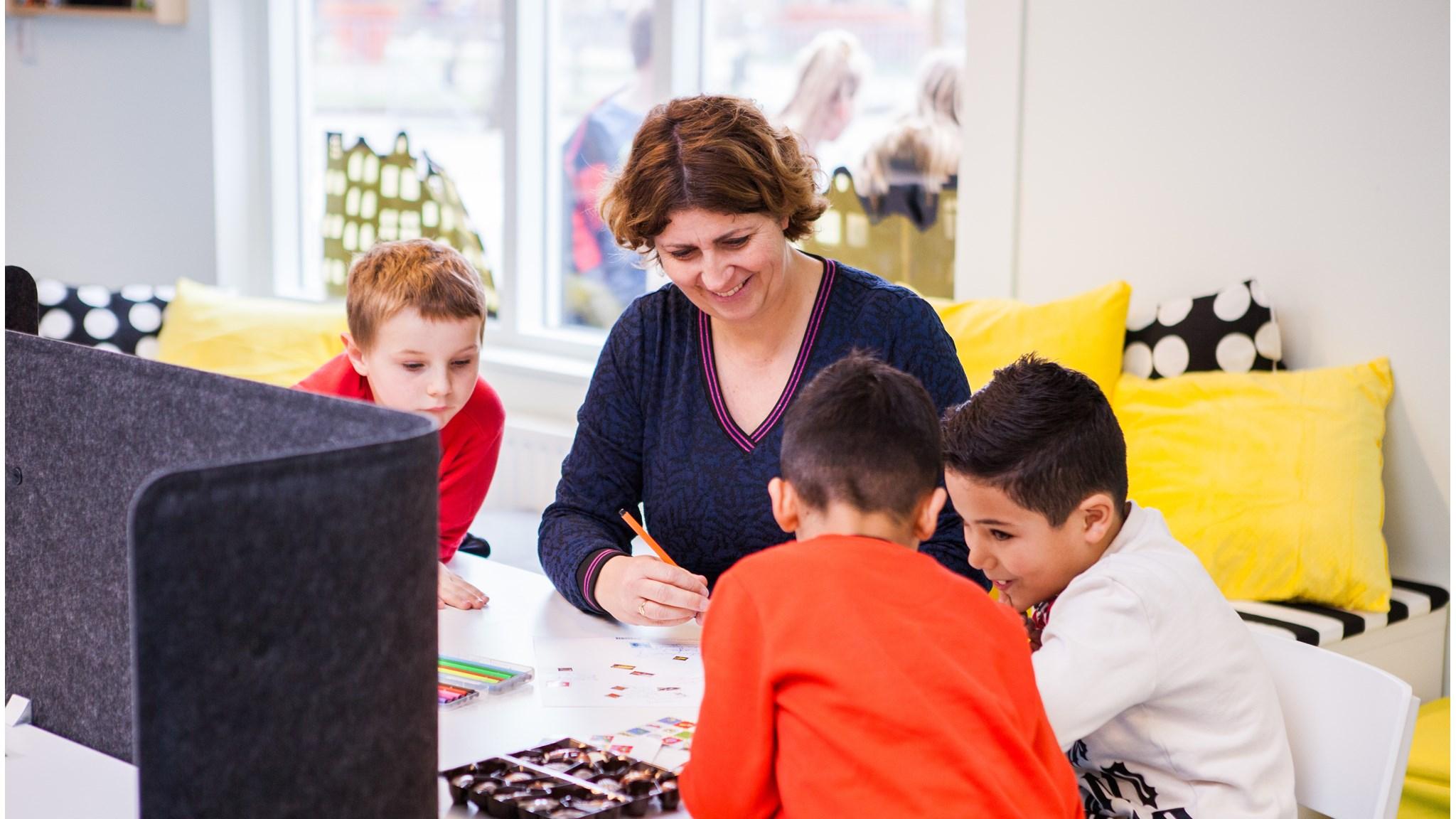 Een leerkracht begeleidt kinderen tijdens een creatieve activiteit op Kids College in Wilnis. Een leerkracht begeleidt kinderen tijdens een creatieve activiteit op Kids College in Wilnis.