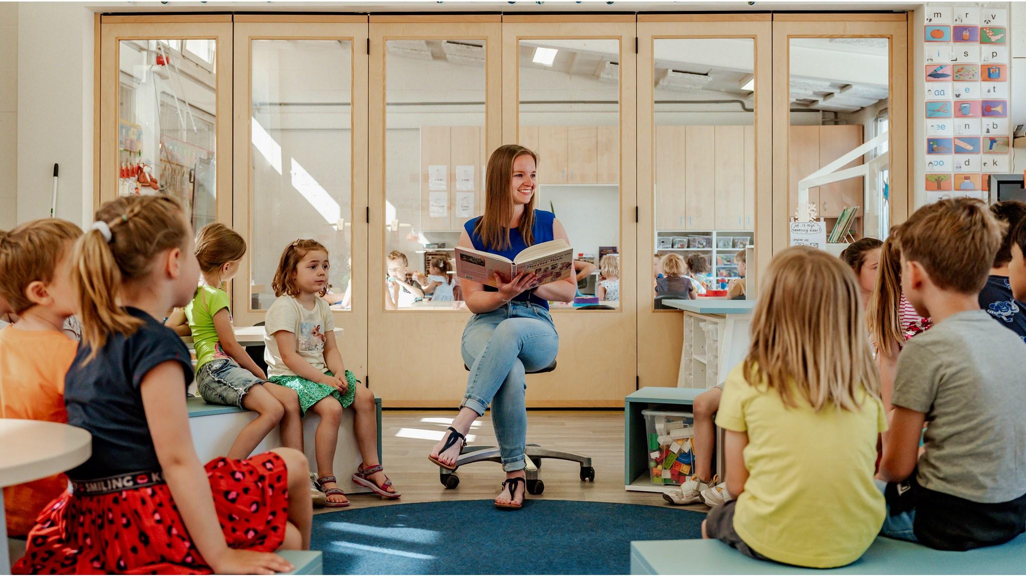 Een leerkracht leest voor aan een groep kinderen in Kindcentrum Amby in Maastricht. Een leerkracht leest voor aan een groep kinderen in Kindcentrum Amby in Maastricht.