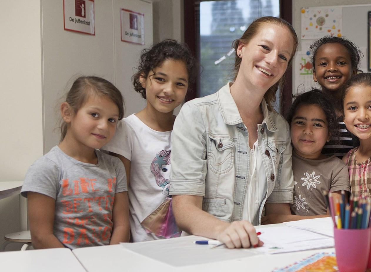 Een leerkracht met lachende kinderen in De Kwartiermaker in Den Bosch. Een leerkracht met lachende kinderen in De Kwartiermaker in Den Bosch.