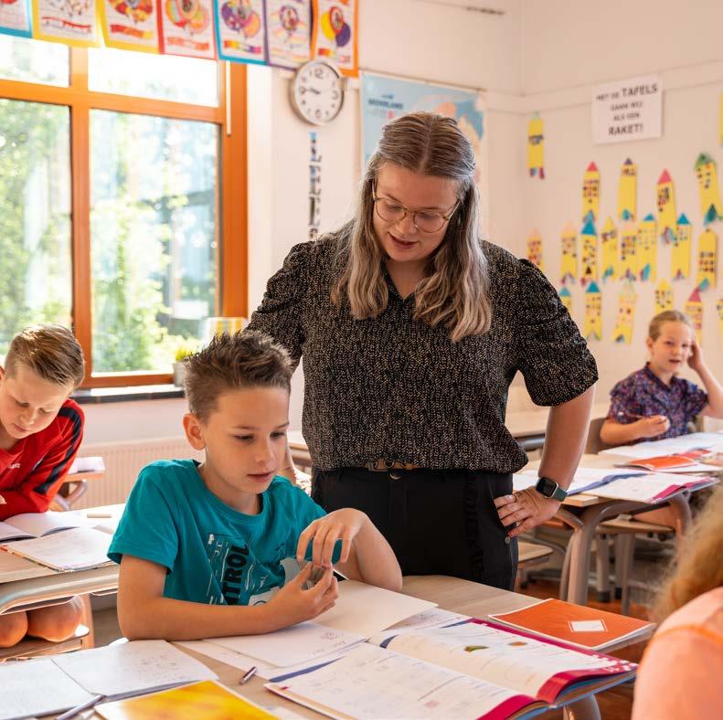 Een leerkracht van Basisschool Lambertus in Vessem helpt een leerling met zijn werk aan een bureau in de klas. Een leerkracht van Basisschool Lambertus in Vessem helpt een leerling met zijn werk aan een bureau in de klas.