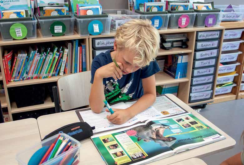 Een leerling aan De Vlindertuin in Voorthuizen werkt geconcentreerd met een schoolboek en schrijfgerei aan een bureau. Een leerling aan De Vlindertuin in Voorthuizen werkt geconcentreerd met een schoolboek en schrijfgerei aan een bureau.