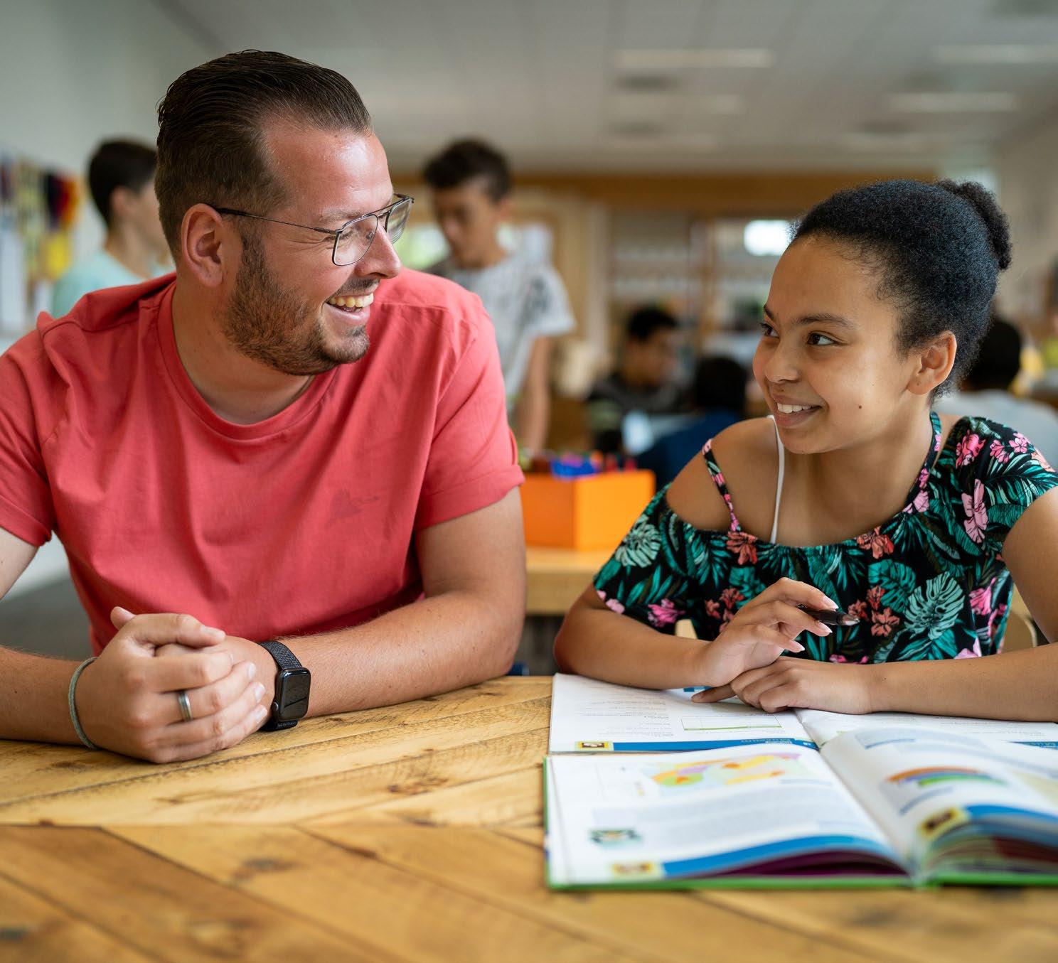 Een leerling en een docent lachen samen tijdens het leren aan de Synergieschool St Alfonsus voor basisonderwijs in Roermond. Een leerling en een docent lachen samen tijdens het leren aan de Synergieschool St Alfonsus voor basisonderwijs in Roermond.