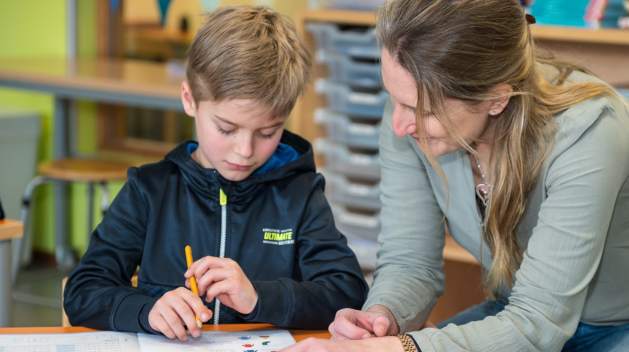 Een leerling en een leerkracht werken samen aan een opdracht in Basisschool Swartbroek in Weert. Een leerling en een leerkracht werken samen aan een opdracht in Basisschool Swartbroek in Weert.