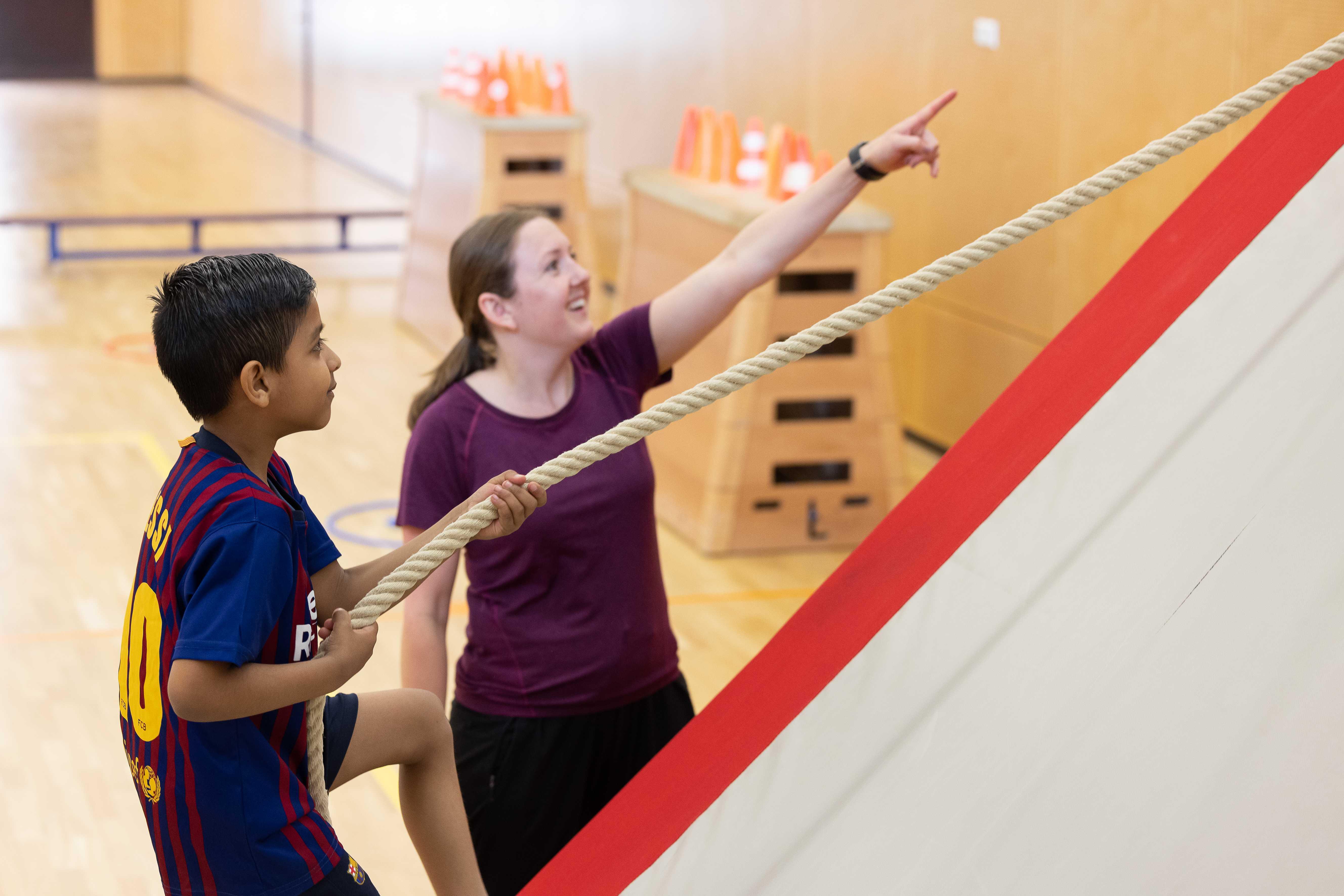 Een leerling en een leraar in de gymzaal van IKC De Achtsprong in Zoetermeer tijdens een sportieve activiteit. Een leerling en een leraar in de gymzaal van IKC De Achtsprong in Zoetermeer tijdens een sportieve activiteit.