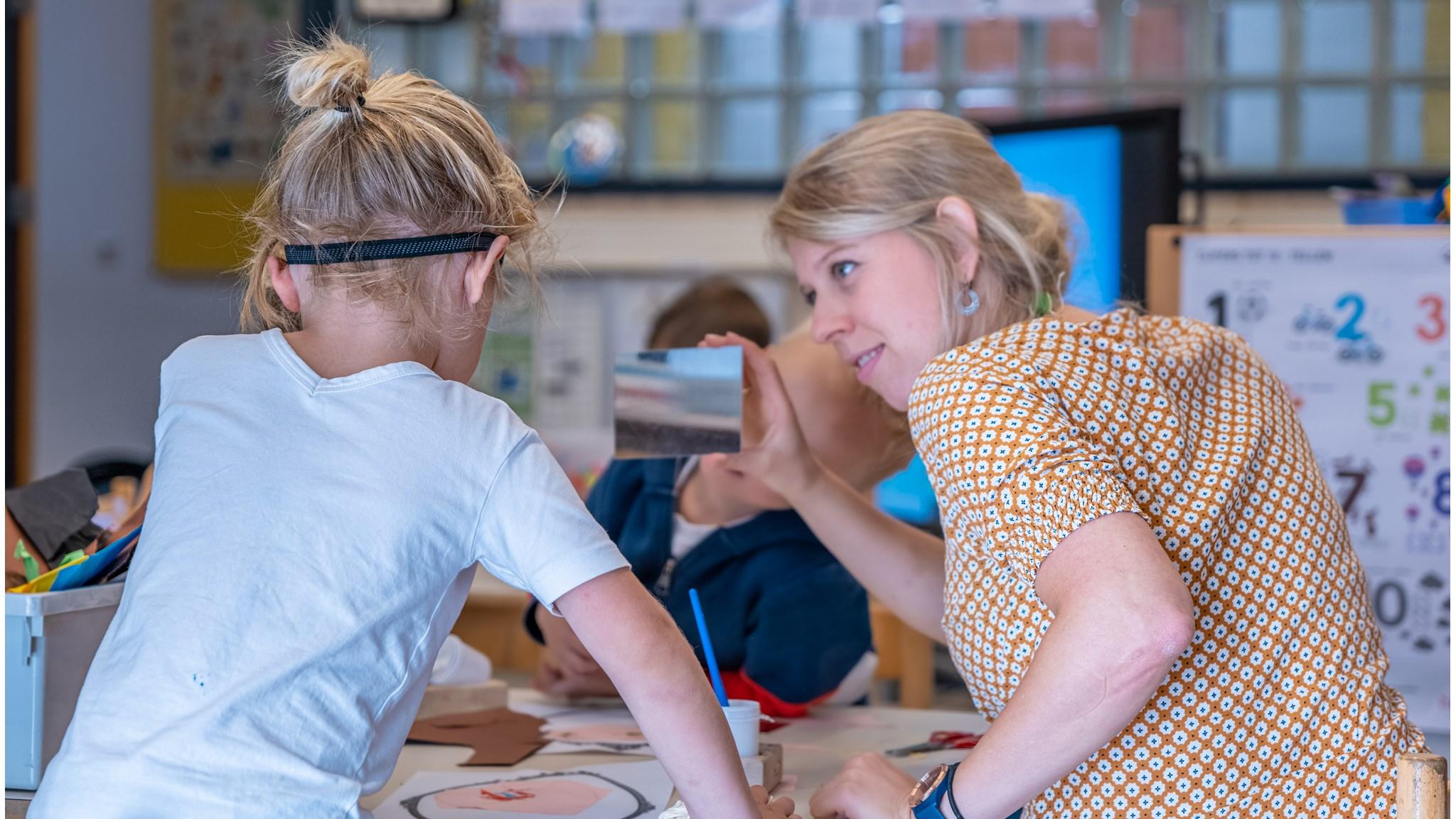 Een leerling en een lerares interactief aan het werk met een spiegel in De Zonnewijzer in Dronten. Een leerling en een lerares interactief aan het werk met een spiegel in De Zonnewijzer in Dronten.