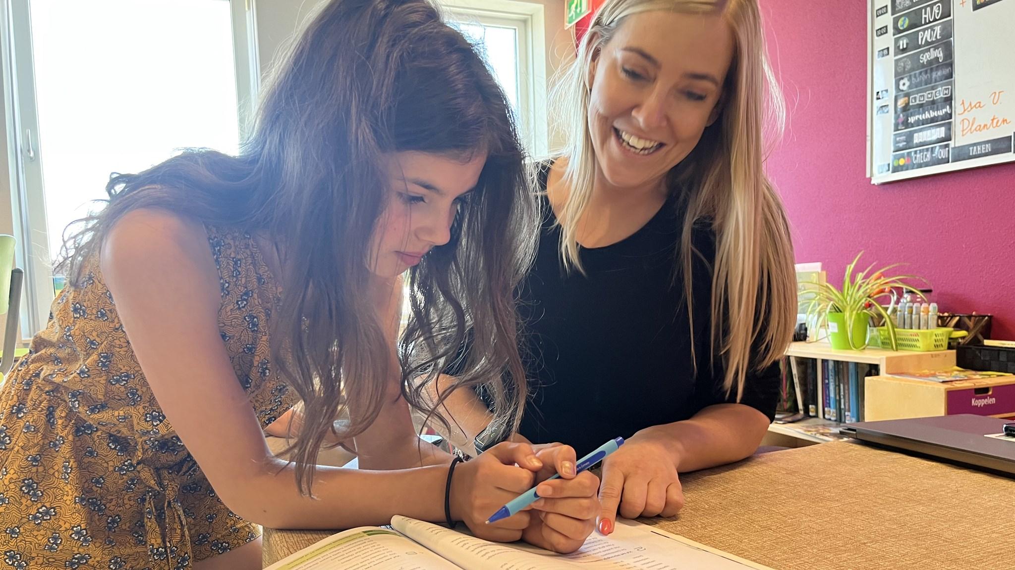 Een leerling en een lerares van obs Prinses Wilhelmina in Lexmond werken samen aan een schoolopdracht.
