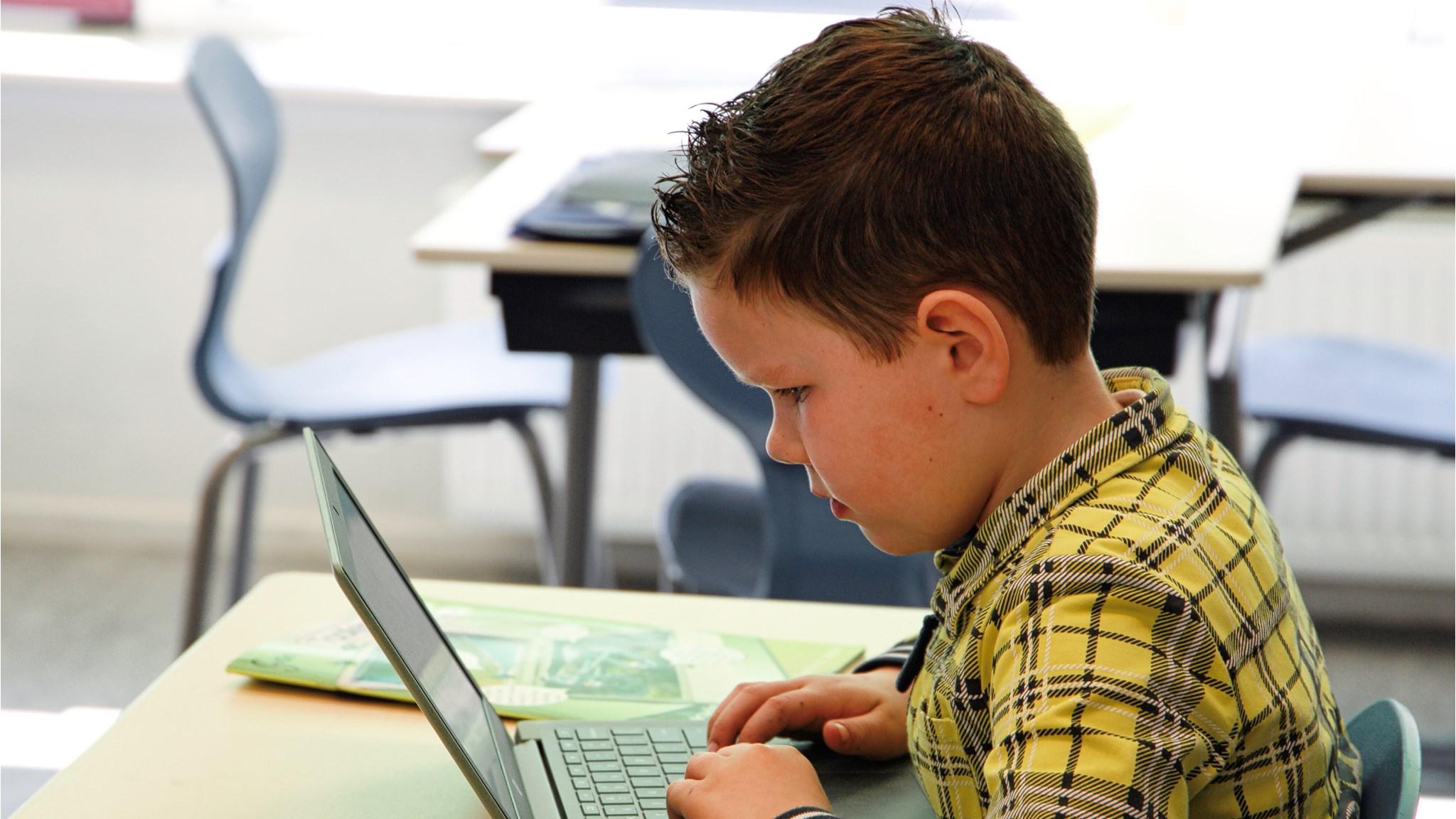 Een leerling van Basisschool De Handpalm - school met de Bijbel in Leens werkt geconcentreerd op zijn laptop. Een leerling van Basisschool De Handpalm - school met de Bijbel in Leens werkt geconcentreerd op zijn laptop.