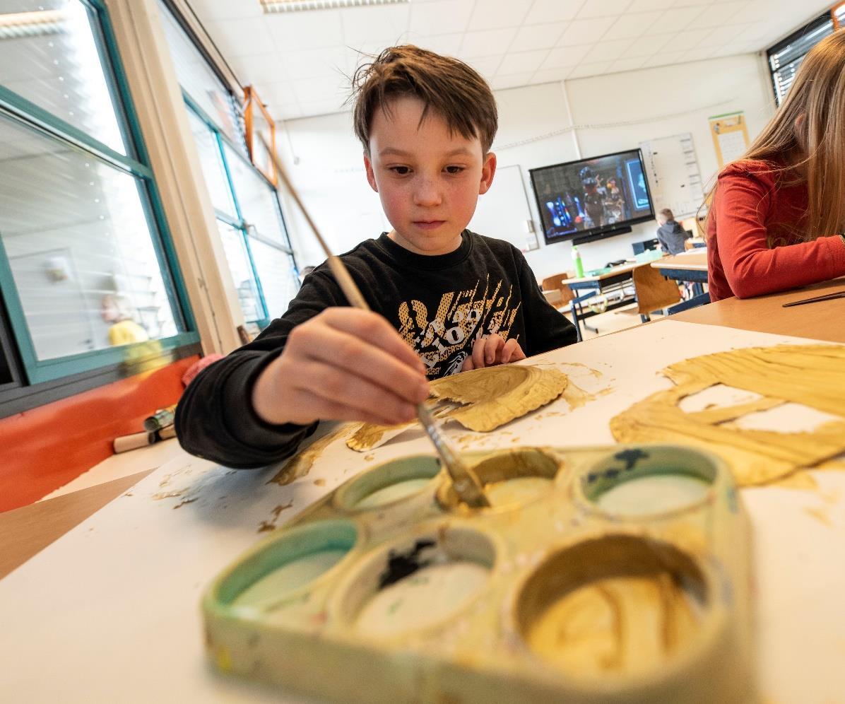 Een leerling van basisschool Het Mozaïek in Almelo is bezig met schilderen in de klas. Een leerling van basisschool Het Mozaïek in Almelo is bezig met schilderen in de klas.