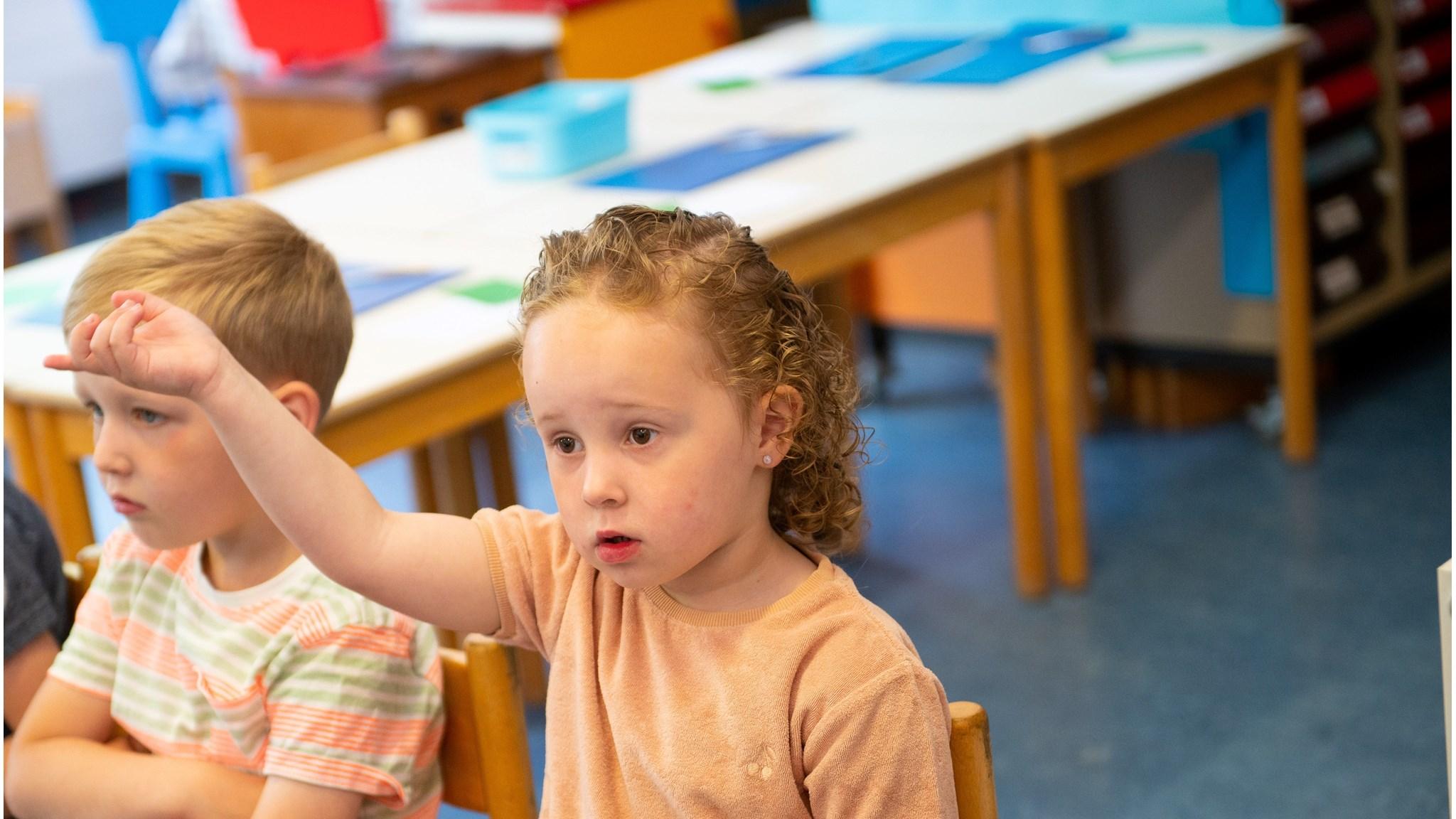 Een leerling van Basisschool Oranje Nassau - school met de Bijbel in Kootstertille steekt haar hand op tijdens een les. Een leerling van Basisschool Oranje Nassau - school met de Bijbel in Kootstertille steekt haar hand op tijdens een les.